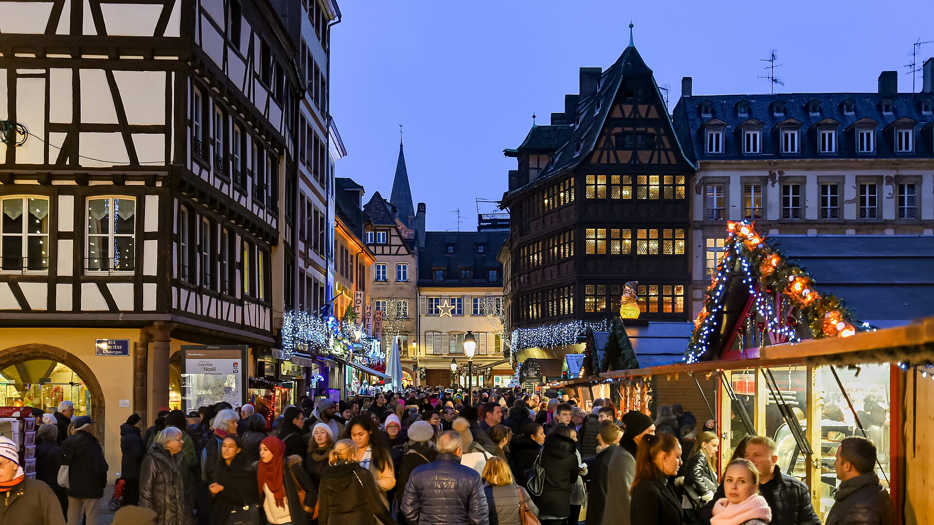 European Christmas market glowing at night among half-timbered houses
